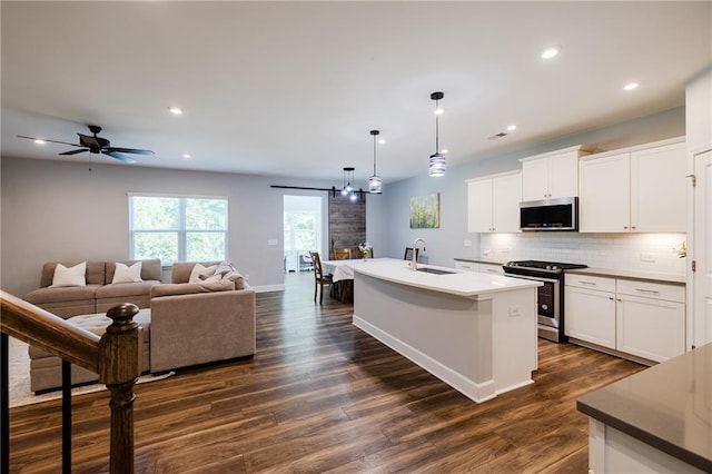 5440 Wheeler Ridge Rd, Auburn, GA 30011 - kitchen featuring stainless steel appliances, dark wood-style floors, a sink, decorative backsplash, and an island with sink