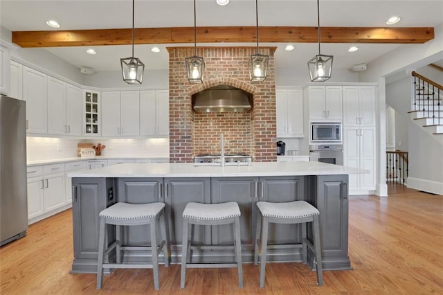 kitchen featuring white cabinetry, stainless steel appliances, and light wood finished floors