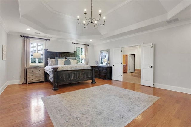 bedroom with a chandelier, a tray ceiling, baseboards, ornamental molding, and visible vents