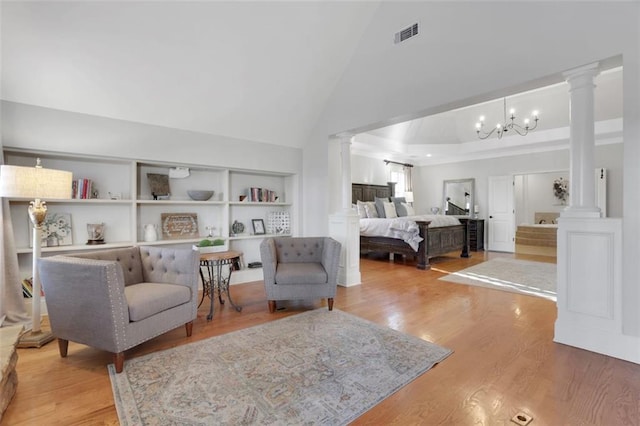 living area with high vaulted ceiling, wood finished floors, visible vents, and ornate columns