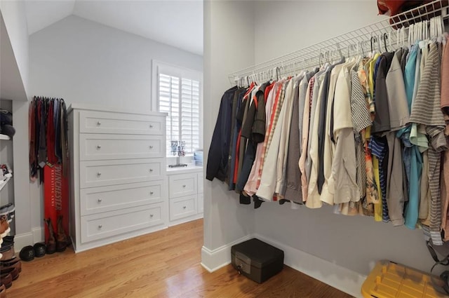 walk in closet featuring light wood-style floors and lofted ceiling