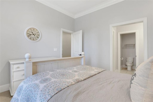 bedroom featuring ensuite bath, baseboards, and ornamental molding