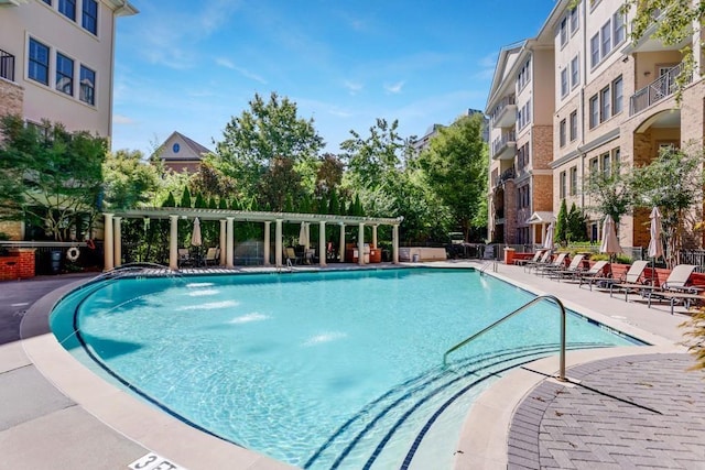 view of pool featuring pool water feature, a patio area, and a pergola