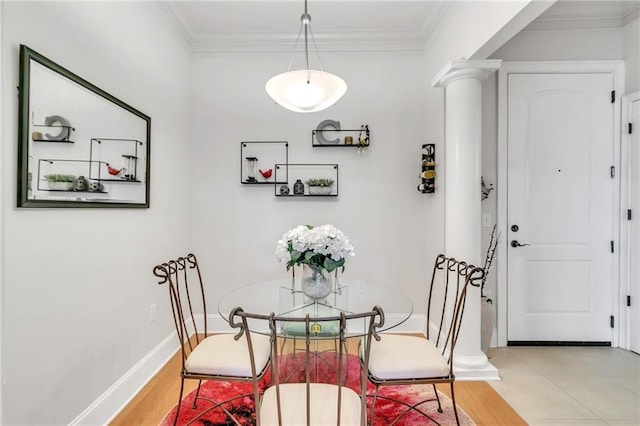 dining space featuring decorative columns, hardwood / wood-style flooring, and ornamental molding