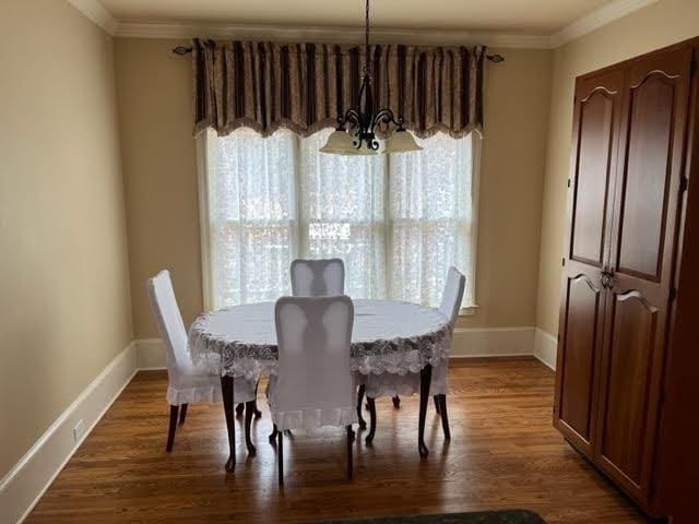 dining room featuring baseboards, ornamental molding, and dark wood finished floors