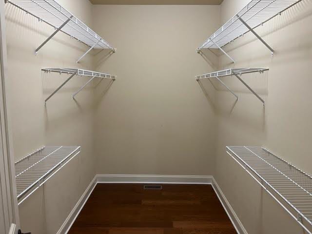 walk in closet featuring wood finished floors and visible vents