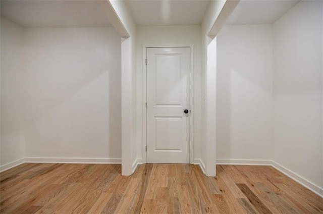 hallway with light wood-style flooring and baseboards