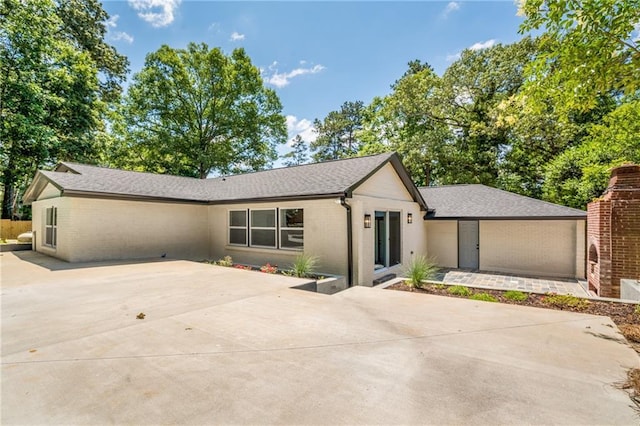 single story home with roof with shingles and brick siding