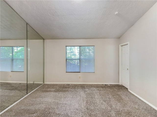 unfurnished bedroom featuring a textured ceiling and carpet