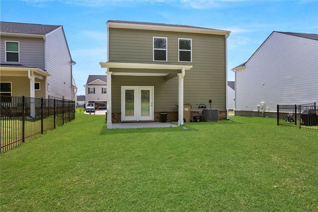 back of property with french doors, a yard, a patio, and central AC unit