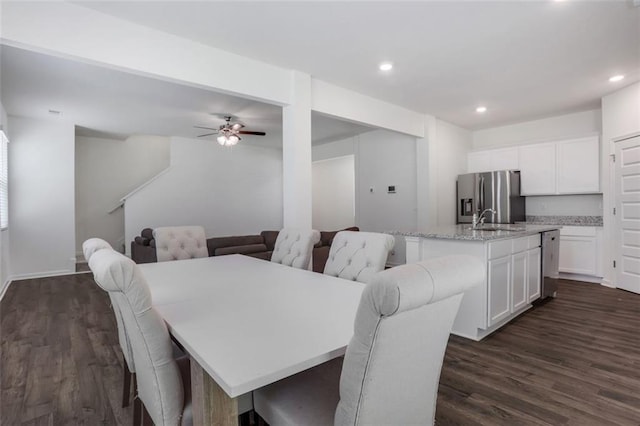 dining room featuring dark hardwood / wood-style flooring, ceiling fan, and sink