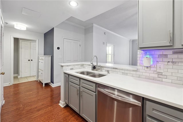 kitchen featuring sink, dishwasher, tasteful backsplash, gray cabinetry, and dark wood-type flooring