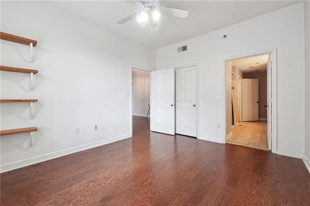 unfurnished bedroom featuring wood finished floors, visible vents, and baseboards