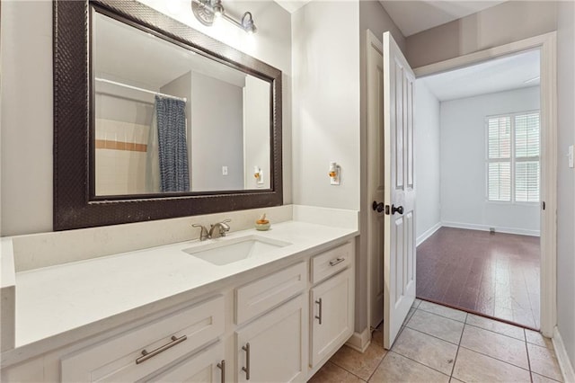 bathroom featuring tile patterned floors, a shower with curtain, baseboards, and vanity