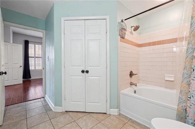 bathroom featuring toilet, shower / bath combination with curtain, and tile patterned floors