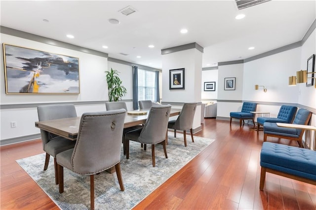 dining room featuring baseboards, visible vents, wood finished floors, and recessed lighting