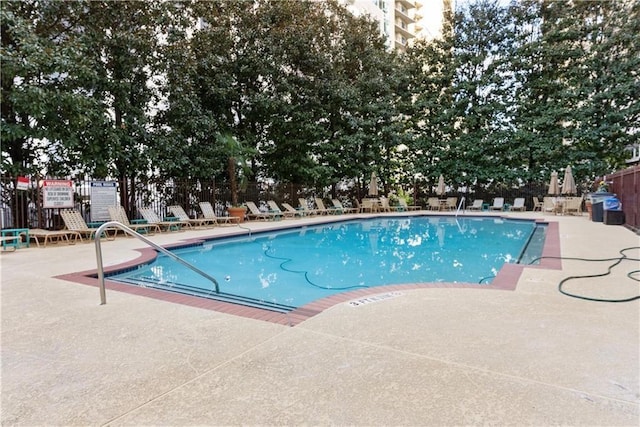 pool with a patio and fence