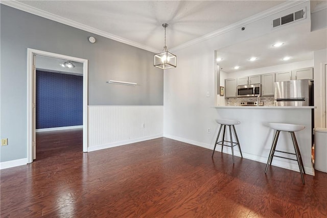 kitchen featuring stainless steel appliances, a peninsula, visible vents, light countertops, and dark wood-style floors