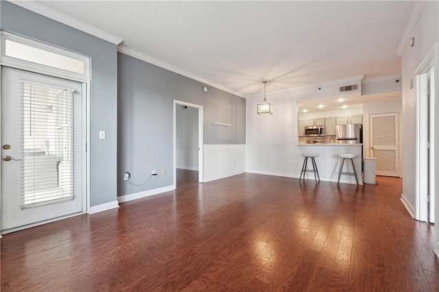 unfurnished living room with dark wood-style floors, visible vents, crown molding, and baseboards