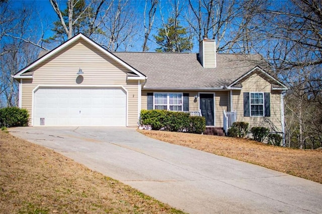 view of front of house with a garage, concrete driveway, roof with shingles, a chimney, and a front yard