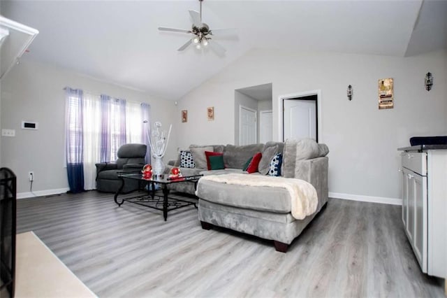 living area with lofted ceiling, baseboards, and wood finished floors