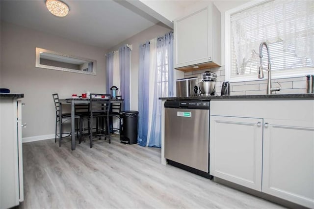 kitchen with light wood-type flooring, white cabinetry, dishwasher, and backsplash