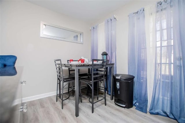 dining area with baseboards and wood finished floors