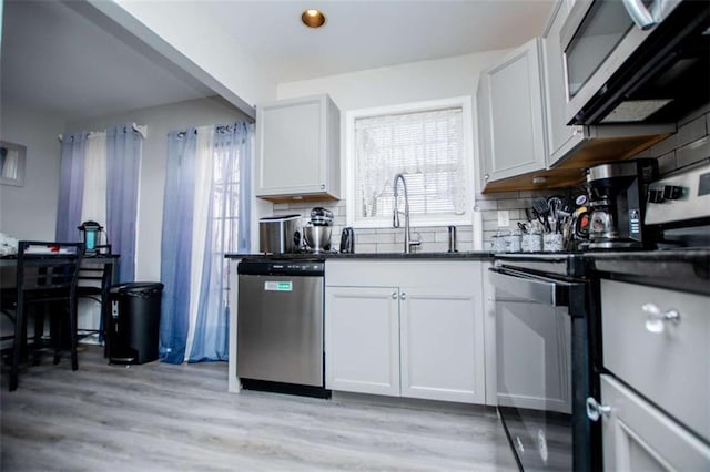 kitchen featuring dark countertops, plenty of natural light, stainless steel appliances, and backsplash