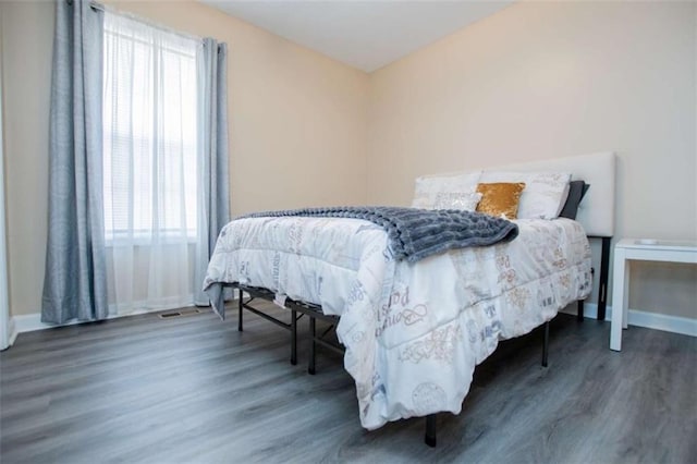 bedroom featuring baseboards and wood finished floors