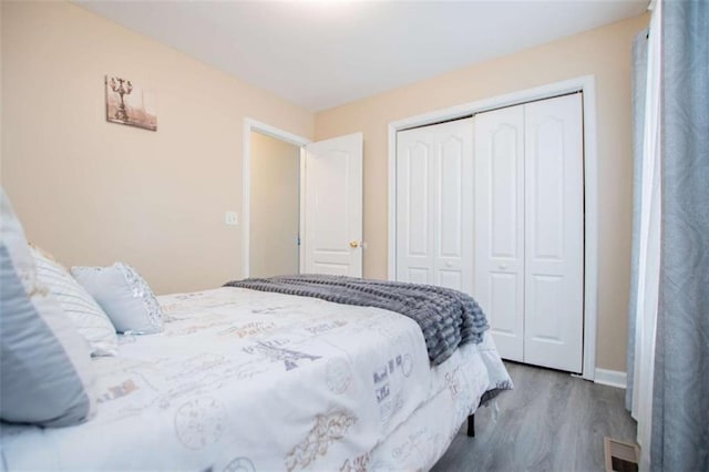 bedroom featuring a closet, wood finished floors, and visible vents