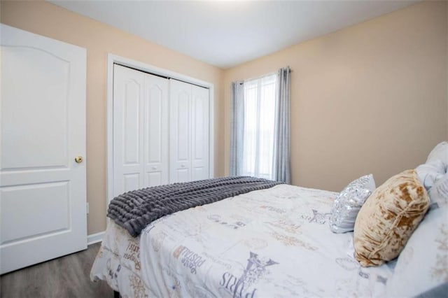 bedroom featuring a closet, wood finished floors, and baseboards