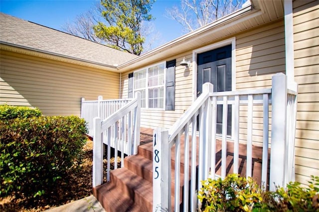 doorway to property with a shingled roof