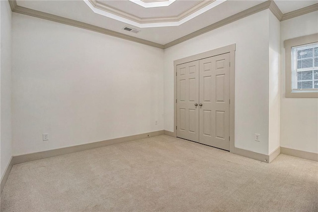 unfurnished bedroom with light carpet, ornamental molding, visible vents, and baseboards