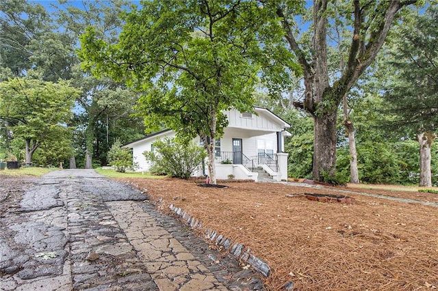 view of front of house with board and batten siding, covered porch, and driveway