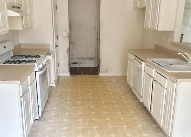 kitchen with white appliances, ventilation hood, white cabinetry, and sink