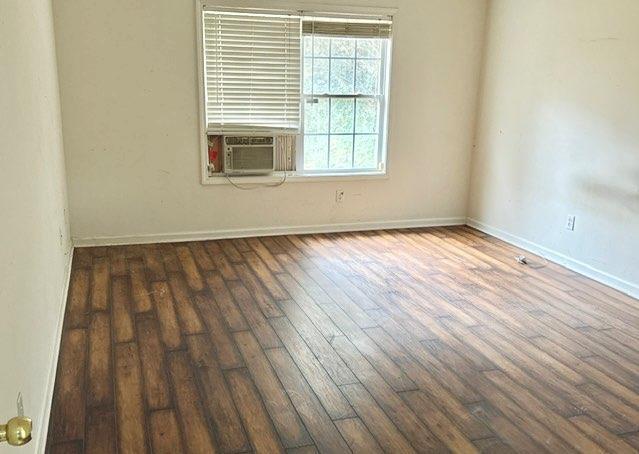 unfurnished room with dark hardwood / wood-style flooring and cooling unit