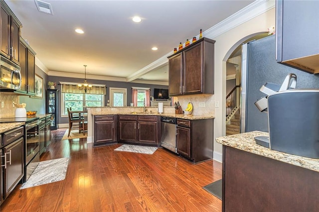 139 Village Park Dr, Newnan, GA 30265 - kitchen with stainless steel appliances, ornamental molding, a peninsula, dark brown cabinets, and arched walkways