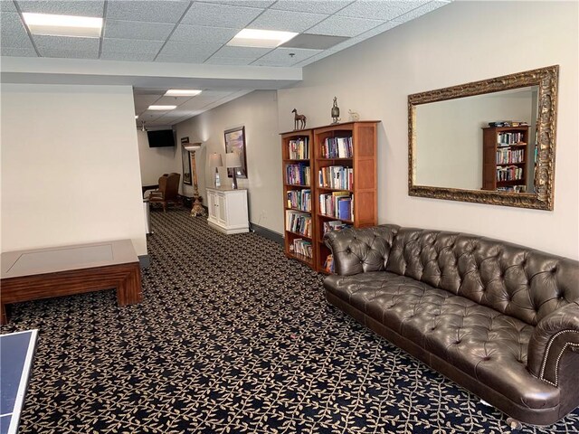 carpeted living room with a drop ceiling