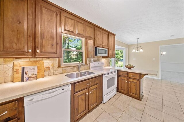 786 Mitsy Pt, Marietta, GA 30068 - kitchen with white appliances, brown cabinetry, a peninsula, a textured ceiling, and light countertops