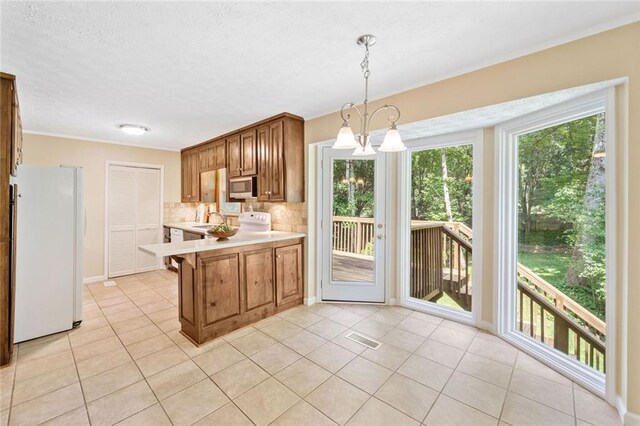 786 Mitsy Pt, Marietta, GA 30068 - kitchen featuring freestanding refrigerator, stainless steel microwave, light countertops, light tile patterned floors, and a textured ceiling
