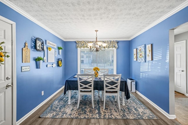 dining space featuring hardwood / wood-style floors, a textured ceiling, an inviting chandelier, and crown molding