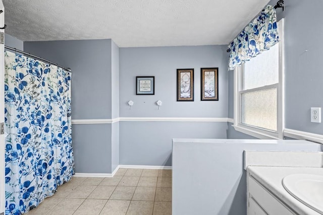 bathroom with a textured ceiling, vanity, and tile patterned floors