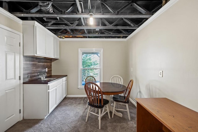 dining room featuring sink and dark carpet