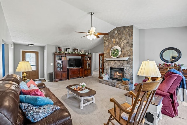 carpeted living room with ceiling fan, a stone fireplace, and lofted ceiling