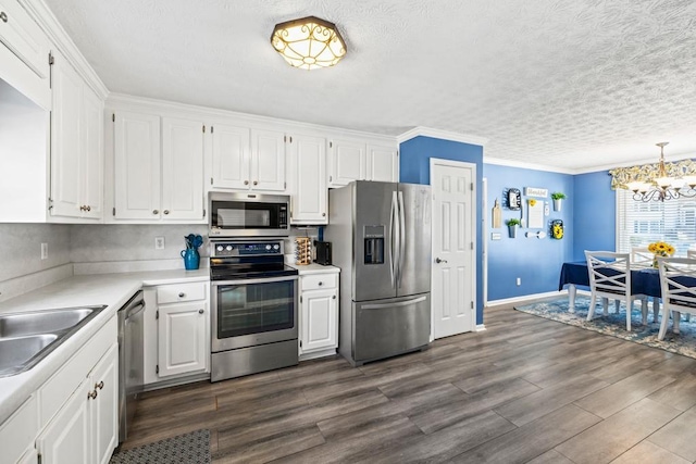 kitchen featuring decorative light fixtures, stainless steel appliances, white cabinetry, and sink