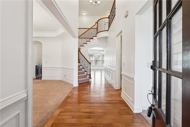 foyer with hardwood / wood-style floors and crown molding