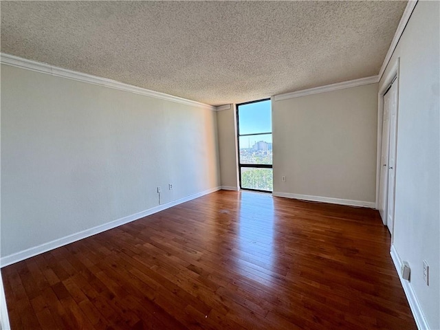 unfurnished room with baseboards, dark wood-style flooring, and crown molding