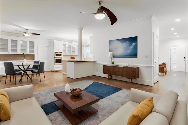 living area featuring recessed lighting, light wood-type flooring, and ceiling fan with notable chandelier