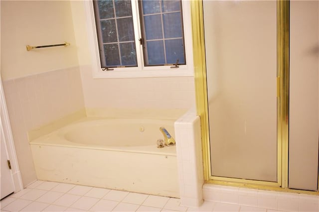 bathroom featuring tile patterned floors, a bath, and a stall shower