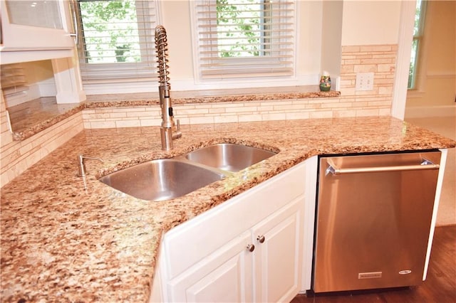 kitchen featuring a sink, a healthy amount of sunlight, decorative backsplash, and stainless steel dishwasher